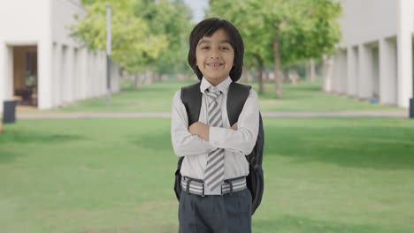 Happy-Indian-school-boy-standing-crossed-hands