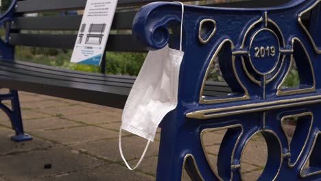 face mask hanging from a bench wide shot