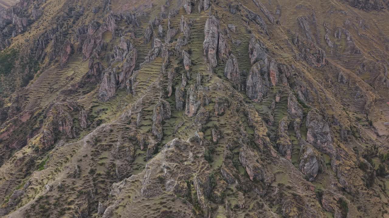 Il drone vola indietro sopra un paesaggio roccioso, strada per le Montagne Arcobaleno, Perù