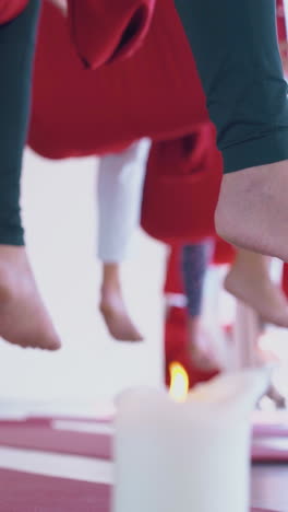 man bare feet hang down against women practicing meditation with fingers in gyan mudra position low angle shot closeup