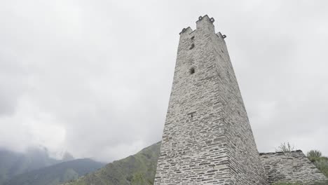 ancient stone tower in a mountainous landscape