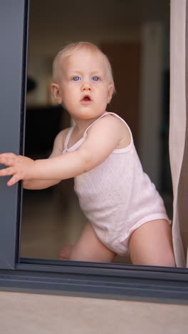 baby girl looking through a window