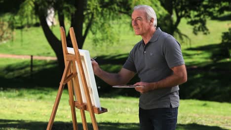 Senior-male-painting-a-canvas