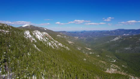 hd drone shot of beautiful lush green large wide open alpine rocky mountains valley during sunny vibrant day in mount evans colorado usa