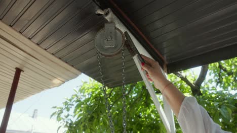 adult woman removing the rust on the pulley with a wire brush