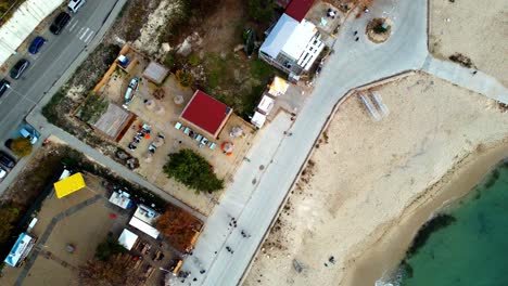 aerial zoom over path walk on black sea beach people in varna bulgaria, tourists at european seaside destination