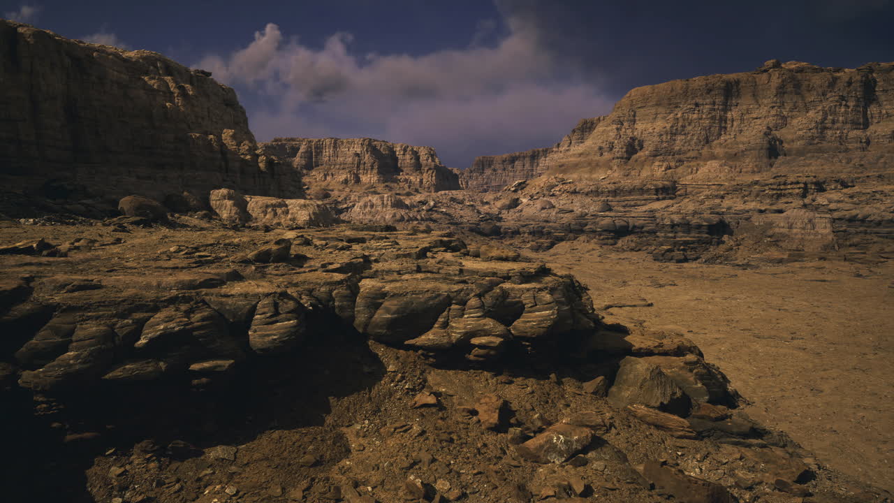 Rocky desert landscape under a dramatic sky with cloud formations at dusk