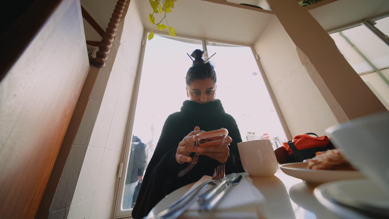 Woman using phone in cafe
