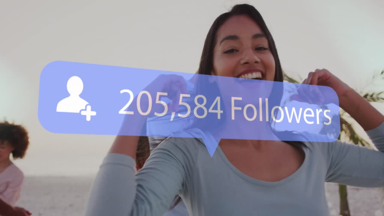 Animation of speech bubble with increasing followers over diverse group of friends dancing at beach