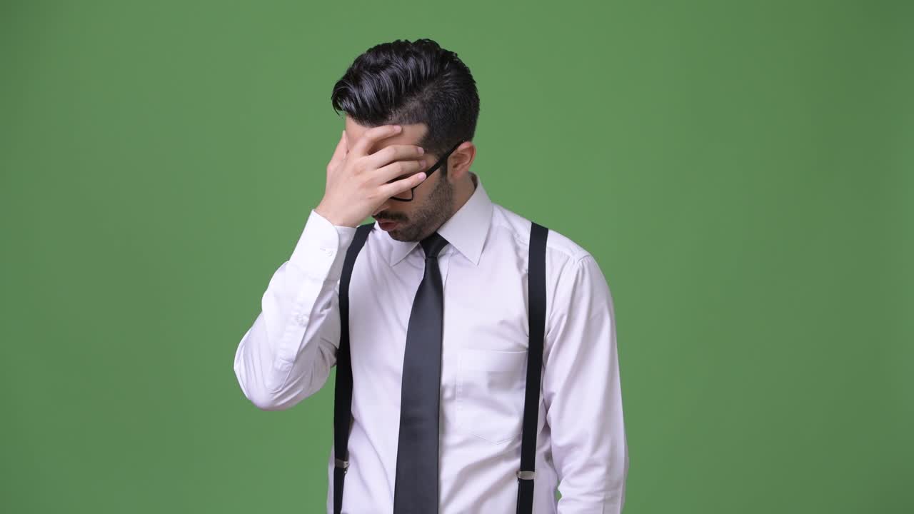 초록색 배경에 젊은 잘생긴 수염을 가진 페르시아 사업가