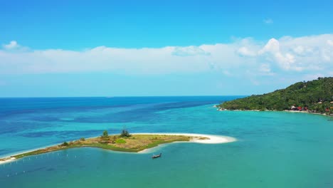 Vivid-colors-of-beautiful-seascape-with-tiny-island-surrounded-by-calm-turquoise-lagoon-under-static-white-clouds-in-Thailand