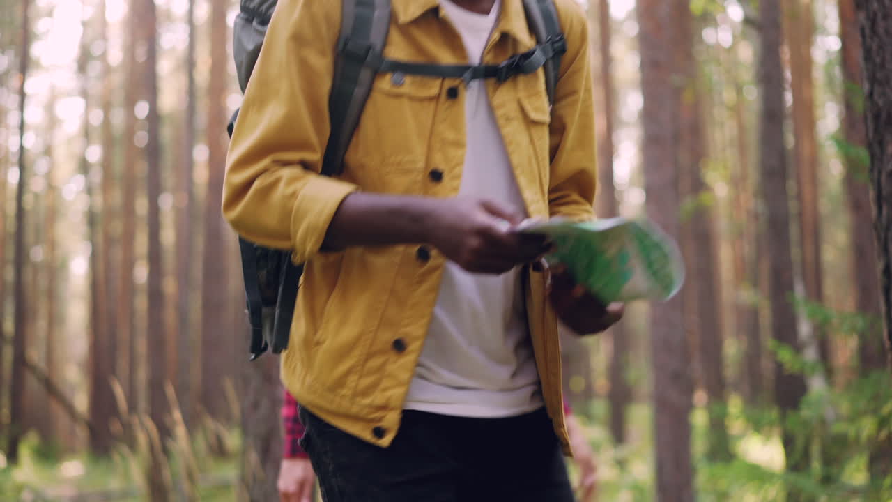 Couple Hiking in a Forest, Using Map for Navigation