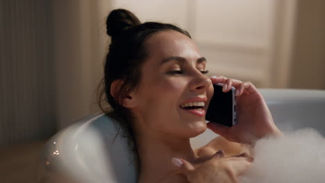 modelo romántico hablando teléfono inteligente bañera fría de primer plano. mujer disfrutando del spa