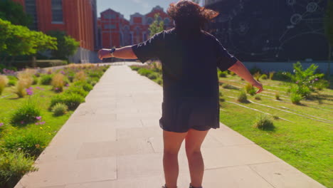 mujer caminando en un parque de la ciudad
