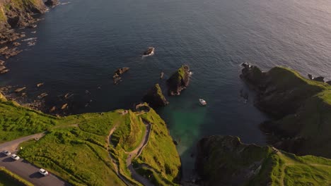 golden sunset light over dunquin pier, with dramatic skies and sea views - dingle co.kerry - 4k cinematic drone footage 09.