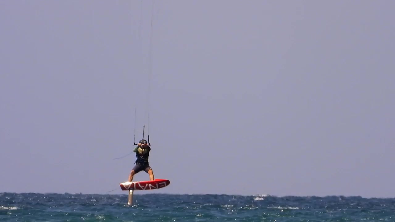 Kitesurfer mengendarai papan hydrofoil di laut lepas
