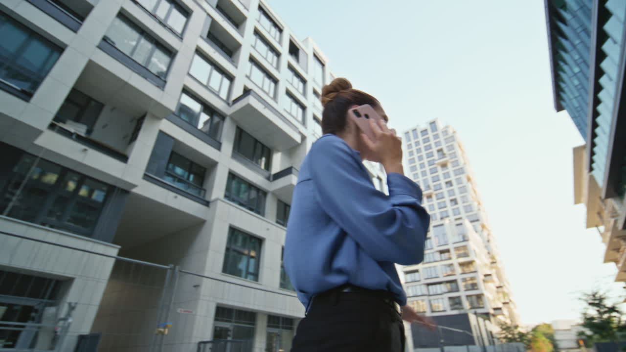 una mujer de negocios furiosa hablando por teléfono móvil en un distrito urbano.