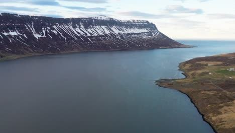 Majestuosos-Fiordos-Islandeses-Con-Montañas-Nevadas-Y-Serenas-Aguas-Azules,-Sin-Presencia-Humana,-Vista-Aérea