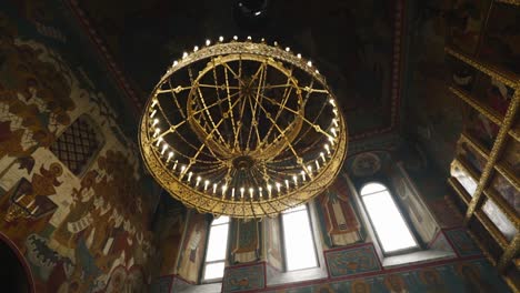 a cool large chandelier hangs on the ceiling of a large temple. beautiful view from below. camera in motion