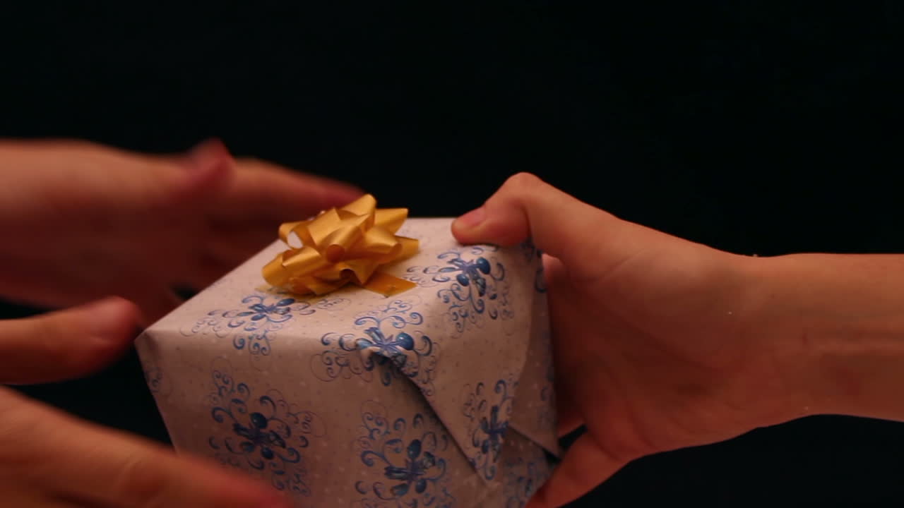 Primer plano de manos intercambiando un regalo envuelto