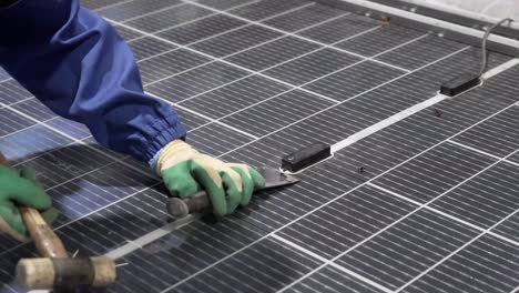 dismantling solar panels: worker reclaiming components in factory.