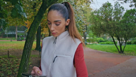 atleta comprobando el rastreador de fitness en la mano en el parque peaceful green.