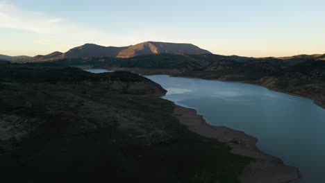 Drone over calm lake. Twilight. Zahara-El Gastor Reservoir.