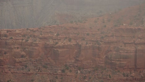 A-tilt-starting-from-heavy-cloud-cover,-slowly-down-to-the-depths-of-the-Grand-Canyon