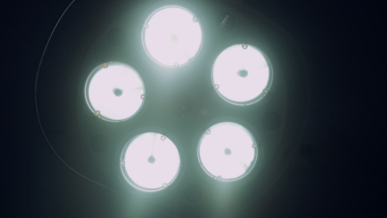 어두운 수술실에서 수술 램프가 켜지고 있습니다. 의료 장비 방.