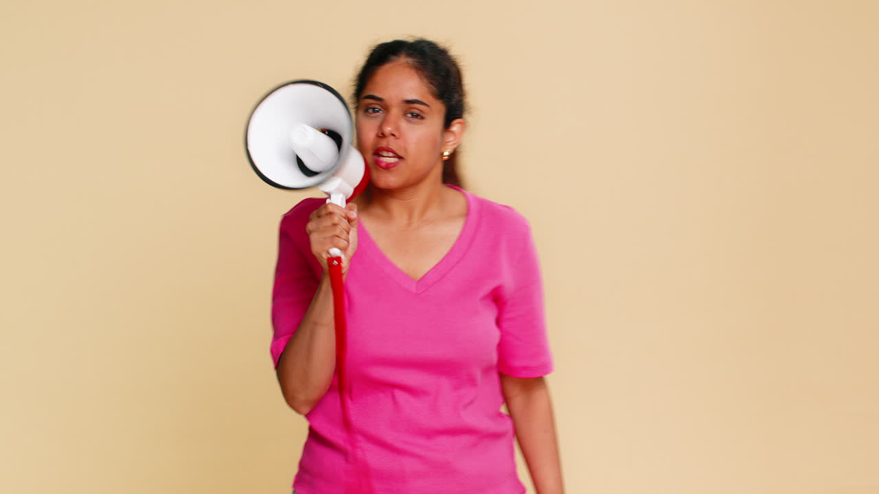 Indian woman energetically speaking into megaphone making announcement or calling with excitement