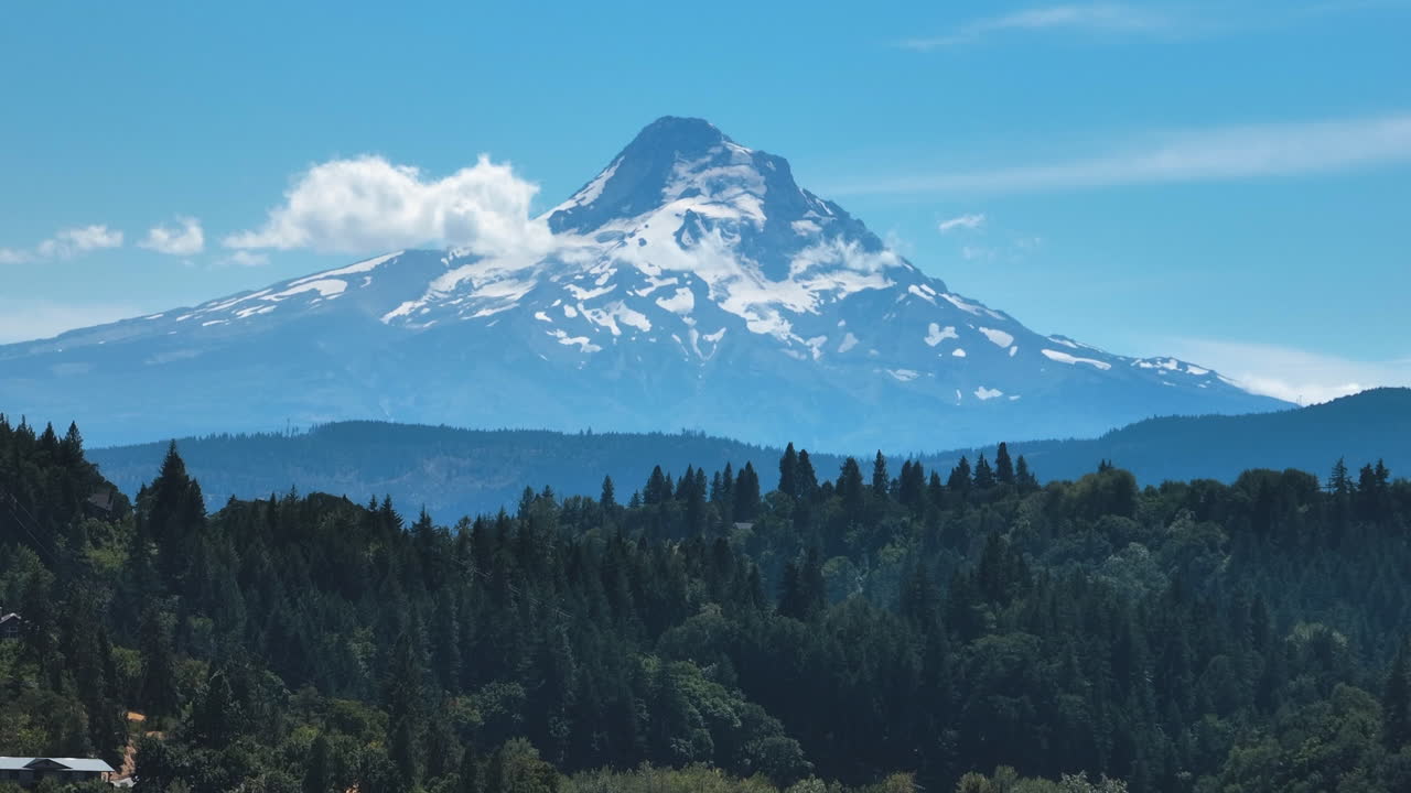 Telephoto drone shot of the snowy Mount Hood mountain, summer in Oregon, USA