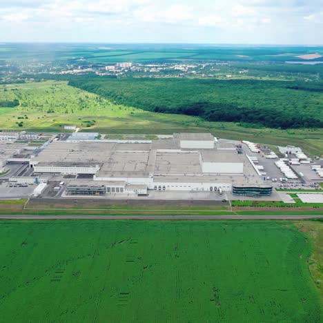 industrial complex among fields. panoramic view of a large manufacturing in green natural environment. aerial view. motion back