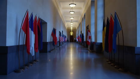 a long, formal hallway lined with international flags