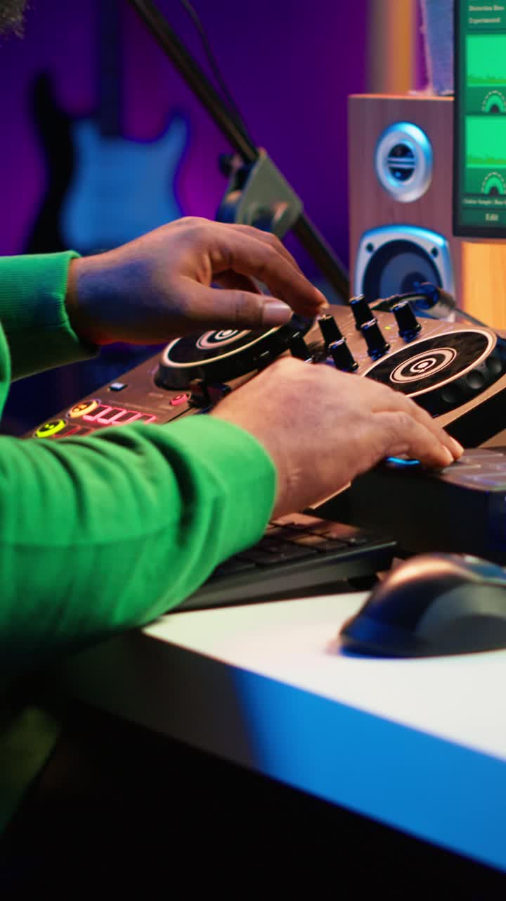 Uomo afroamericano che produce musica in uno studio domestico con un mixer da DJ