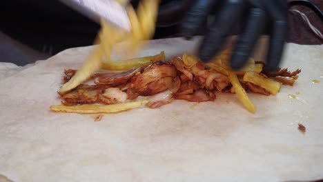 preparing chicken shawarma with fries