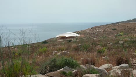 mnajdra megalithic temple complex outdoor on a cloudy day near the ocean water on the island of malta, static shot