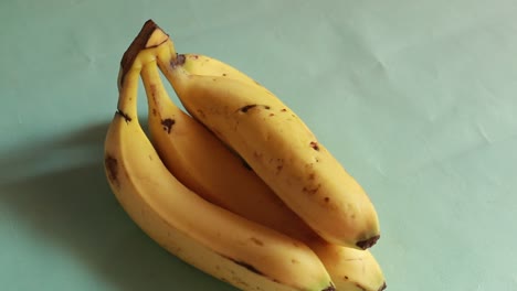 Bündel-Bananen,-Die-Sich-Auf-Grünem-Hintergrund-Drehen