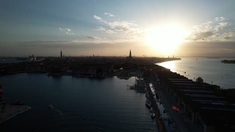 sun rises above venice island, italy, bridge and calm blue sea of italian city of canals, aerial drone flying above idyllic venetian lagoon, sailing boats