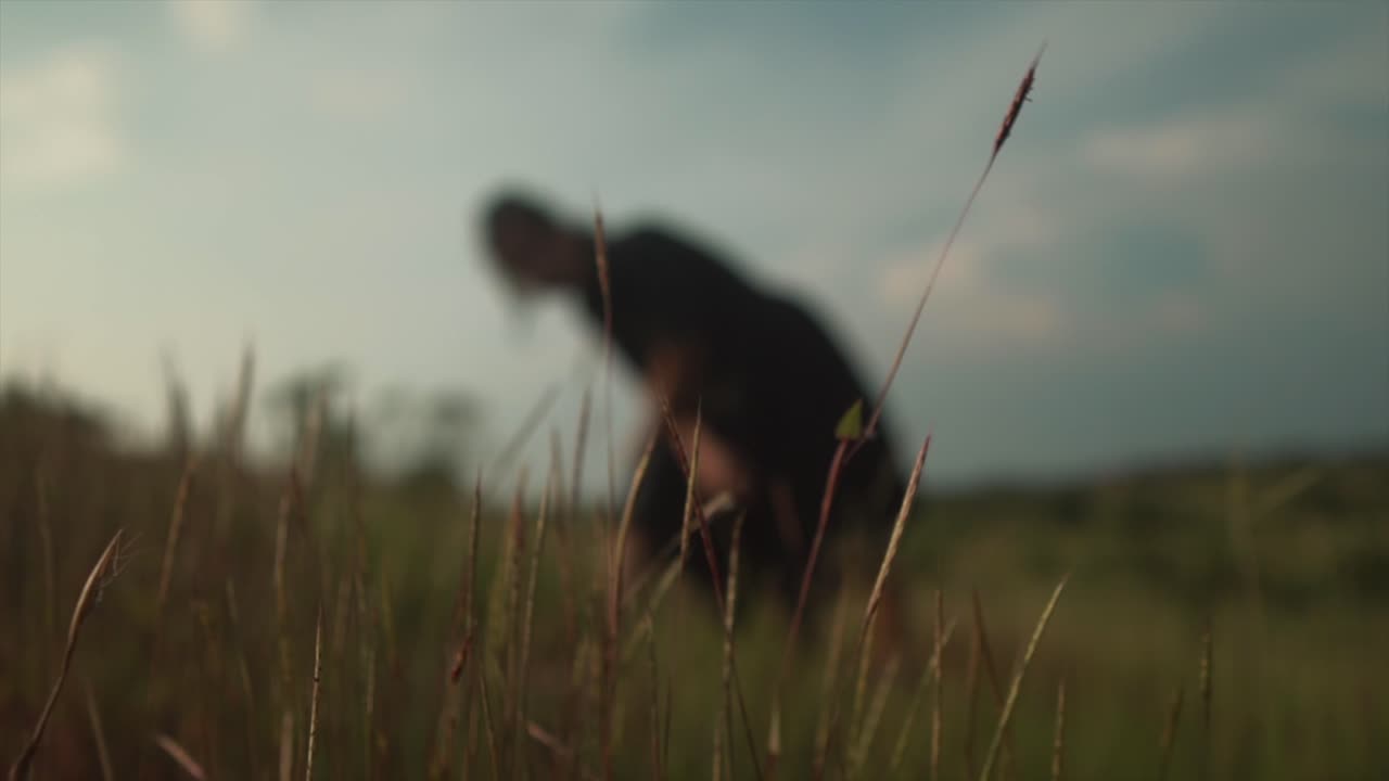 Scatto cinematografico artistico e sfocato di una donna vestita di nero in posa.