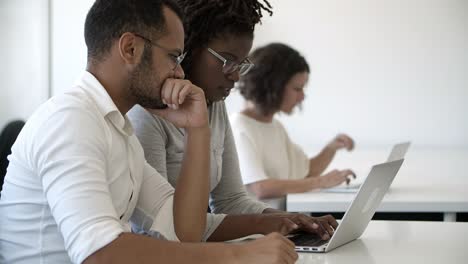 focused employees using laptop while sitting at office