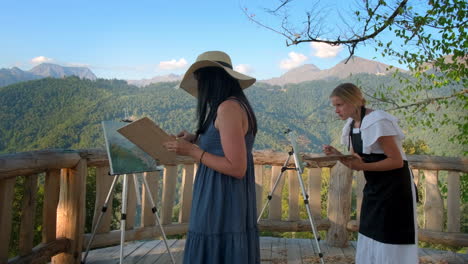 women painting in the mountains