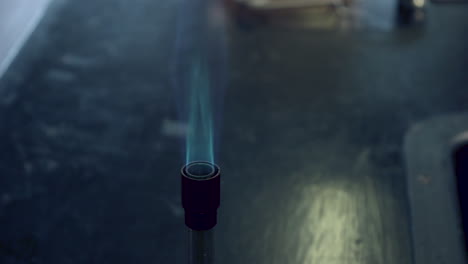 Close-up-of-blue-bunsen-burner-flame-followed-by-strontium-flame-test-burning-red