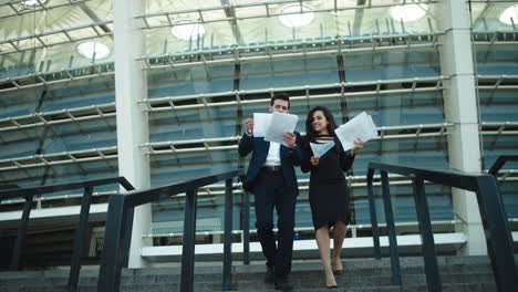 business man and woman going downstairs. man and woman throwing documents