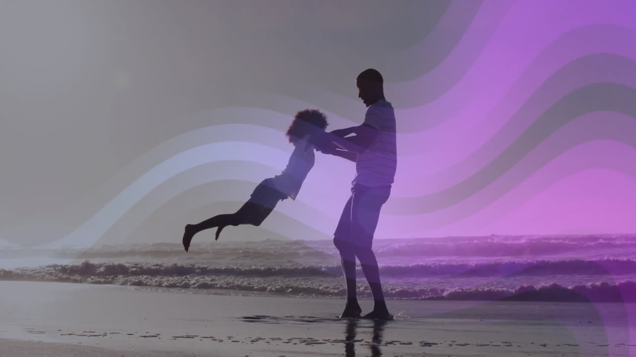 Padre in silhouette che fa dondolare la figlia sul bagnasciuga, con animazione tecnologica di un'onda viola fluttuante
