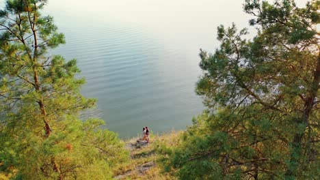 romantic couple hugging at the sea shore. natural landscape of the sunny summer day and young man and a girl kiss each other. aerial view.
