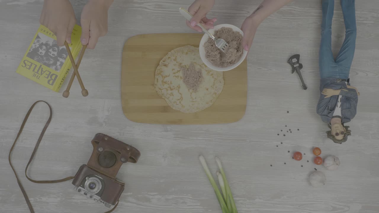 preparando un sándwich de ensalada de atún con una decoración con temas de los beatles