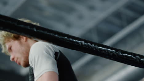 Progressive-kickboxer-gathering-strength-on-ring.-Fighter-regrouping-at-gym