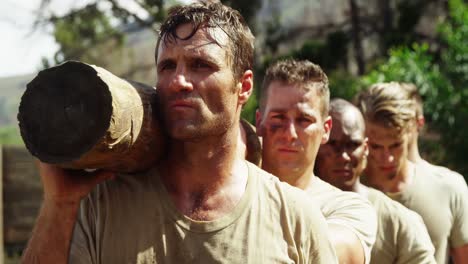 military troops carrying heavy wooden log during obstacle course 4k