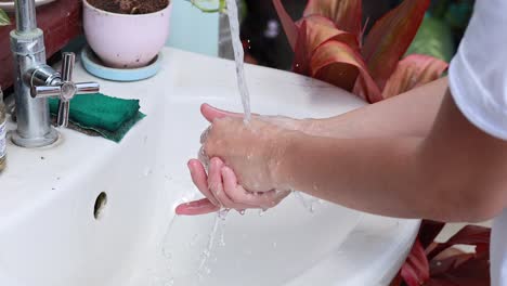 person washing hands at a sink