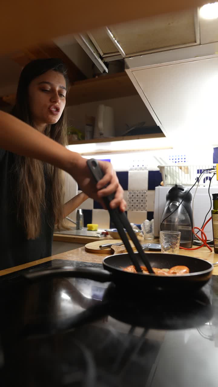 mujer cocinando salchichas y camarones en una cocina